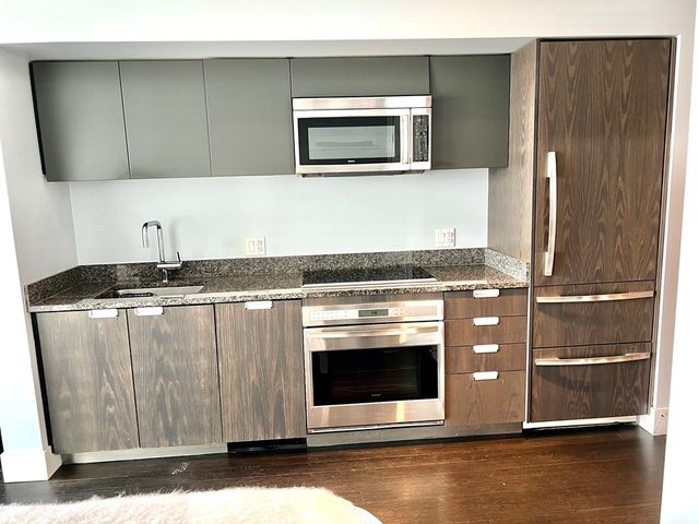 a kitchen with granite countertop a stove and a microwave