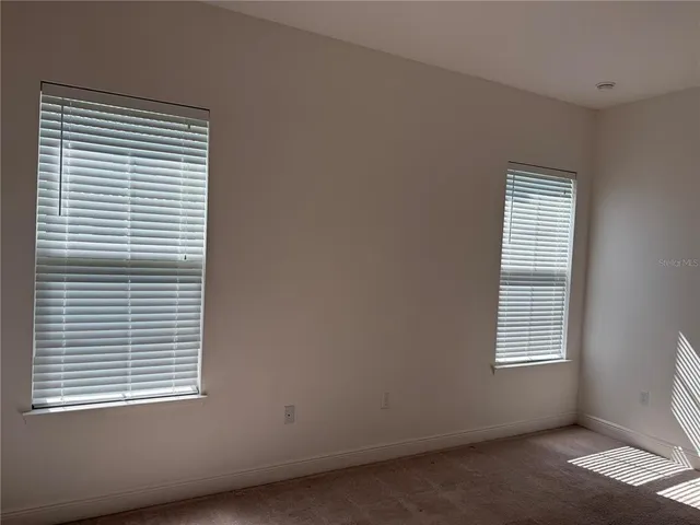 a view of an empty room with window and bathroom