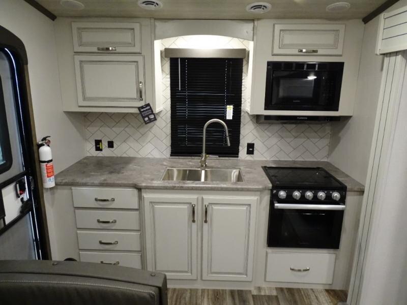 80 Route 6 Wellfleet, MA 02667 - Photo 4 of 23 a kitchen with white cabinets and black appliances