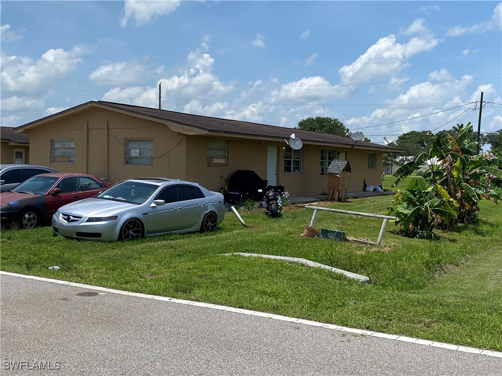 599 Avenue R Moore Haven, FL 33471 - Photo 7 of 23 a front view of a house with a garden and parking space