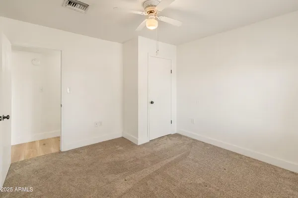 an empty room with a ceiling fan and a window