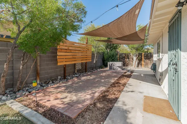 a view of backyard with a table and chair under an umbrella