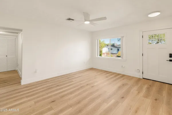 an empty room with wooden floor and window