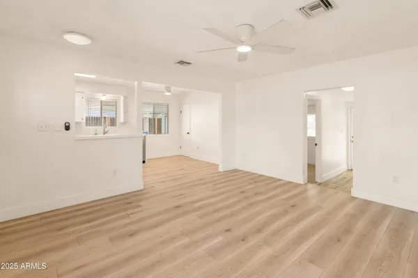 an empty room with wooden floor and windows