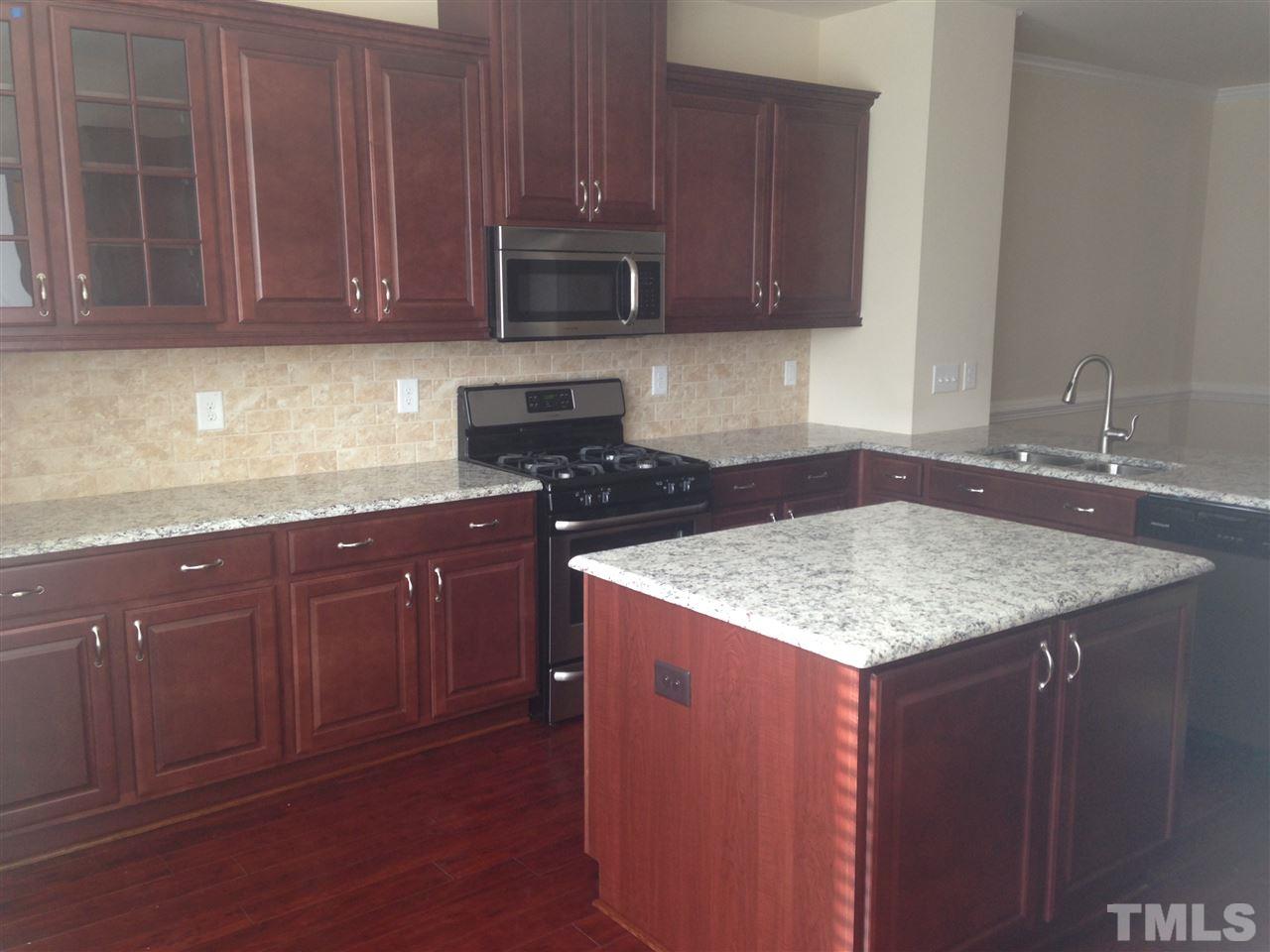 604 Edgewater Ridge Court Apex, NC 27523 - Photo 2 of 20 a kitchen with stainless steel appliances granite countertop a sink stove and microwave