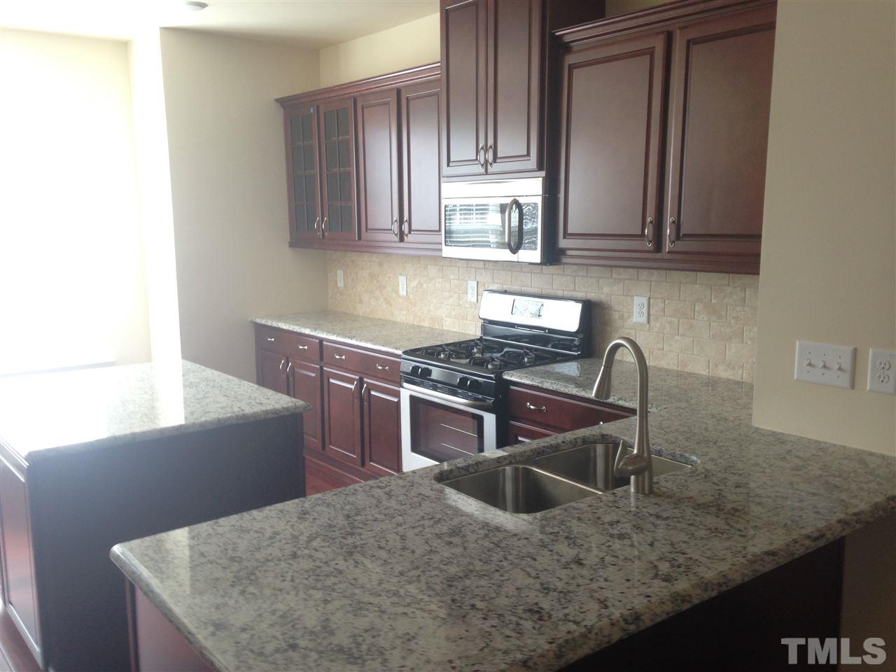 604 Edgewater Ridge Court Apex, NC 27523 - Photo 3 of 20 a kitchen with stainless steel appliances granite countertop a sink a stove and a microwave
