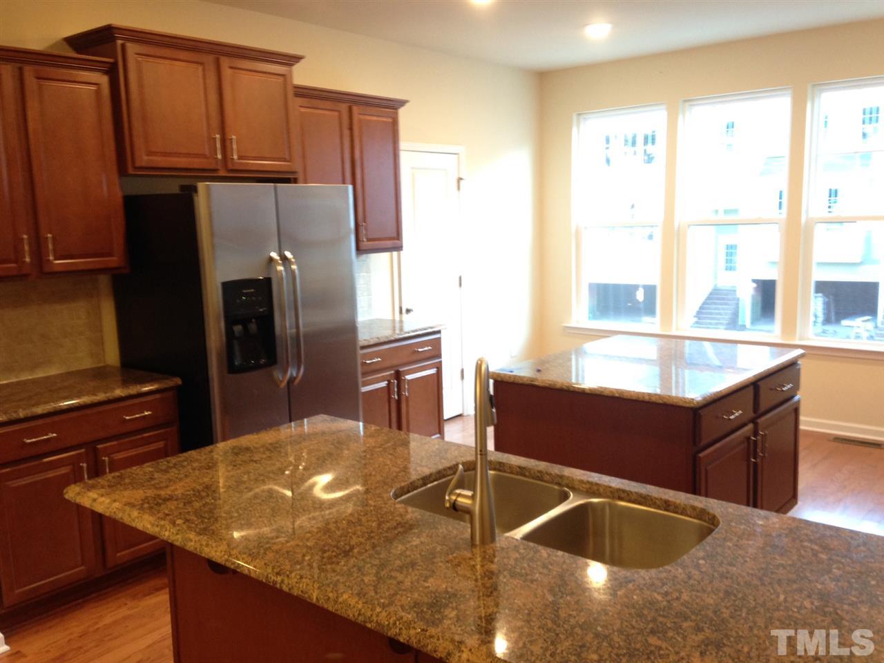 604 Edgewater Ridge Court Apex, NC 27523 - Photo 5 of 20 a kitchen with stainless steel appliances granite countertop a sink a stove and a refrigerator