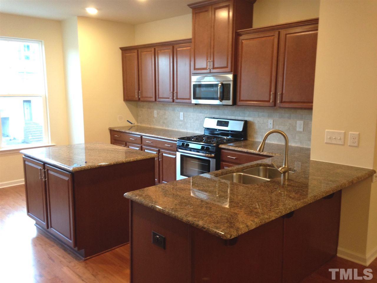 604 Edgewater Ridge Court Apex, NC 27523 - Photo 6 of 20 a kitchen with stainless steel appliances granite countertop a sink a stove and a microwave