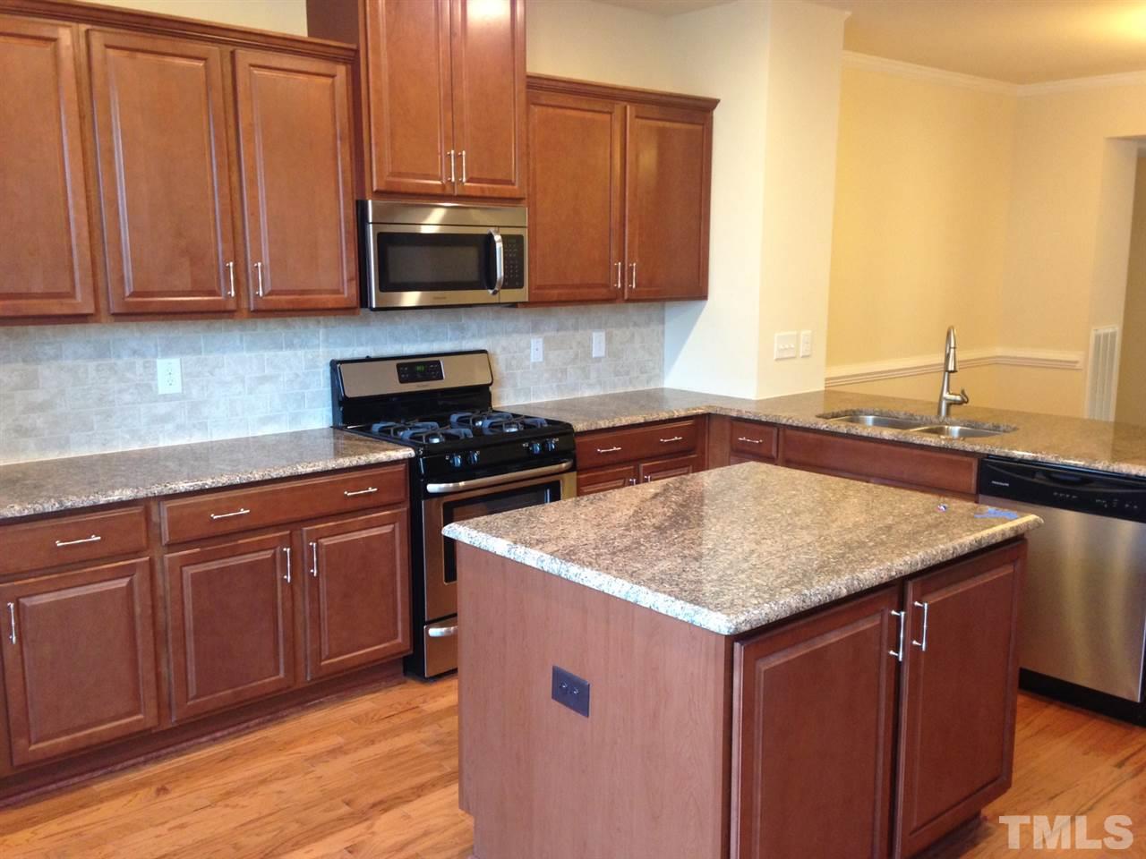 604 Edgewater Ridge Court Apex, NC 27523 - Photo 7 of 20 a kitchen with stainless steel appliances granite countertop a sink stove and microwave