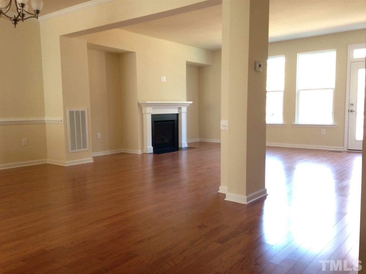 604 Edgewater Ridge Court Apex, NC 27523 - Photo 10 of 20 a view of an empty room with wooden floor and a window