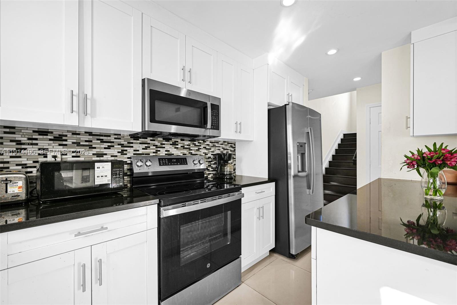 26100 Southwest 134th Place Homestead, FL 33032 - Photo 11 of 39 a kitchen with granite countertop a sink and stainless steel appliances