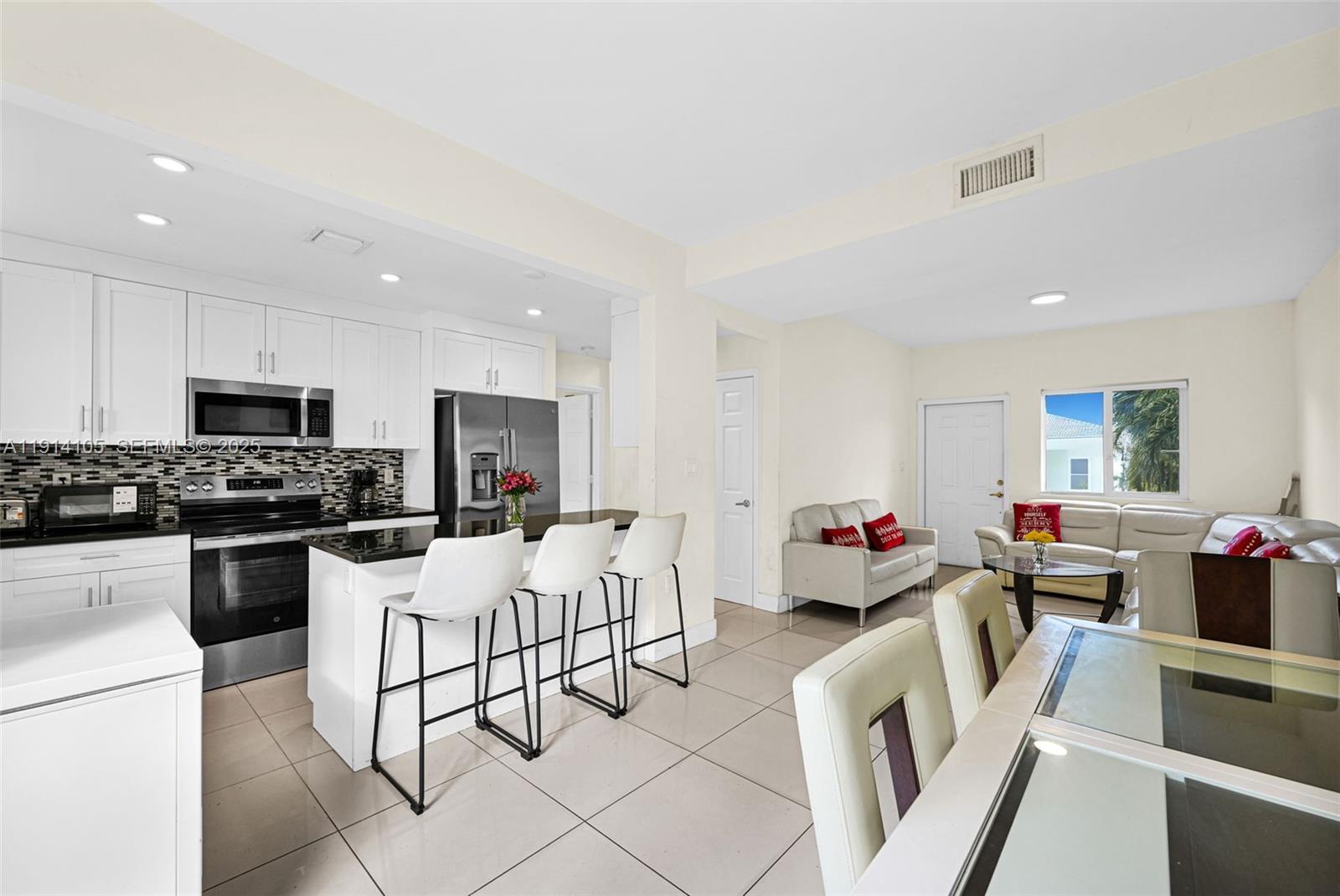 26100 Southwest 134th Place Homestead, FL 33032 - Photo 8 of 39 a living room with stainless steel appliances furniture a flat screen tv and a kitchen view