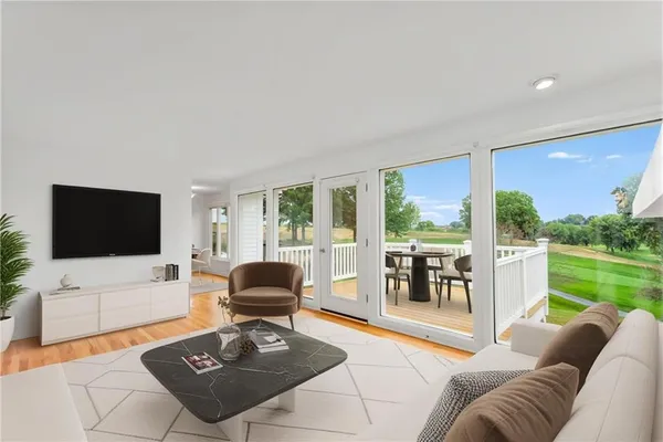 a living room with furniture a flat screen tv and a floor to ceiling window