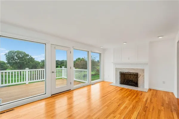 a view of empty room with wooden floor and fireplace