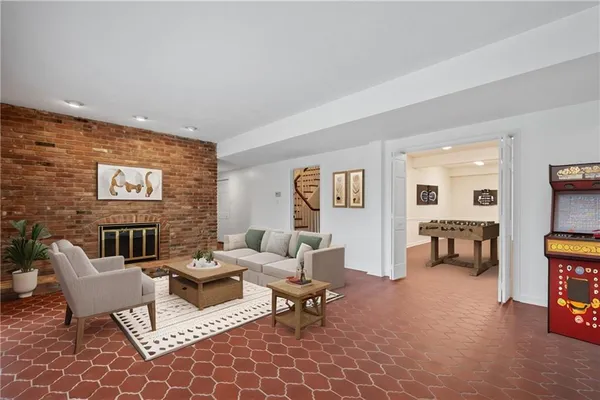 a view of an empty room with wooden floor and a fireplace