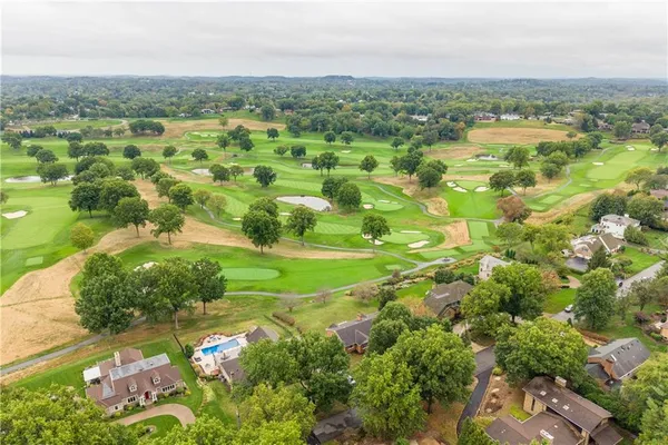 an aerial view of residential houses with outdoor space and trees