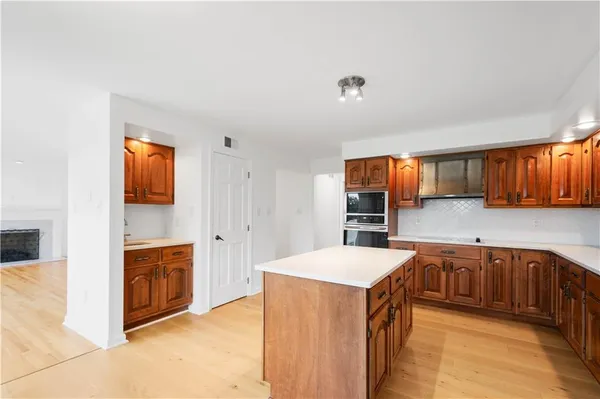 a large kitchen with stainless steel appliances granite countertop a sink and cabinets