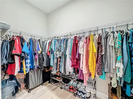 a view of walk in closet with clothes