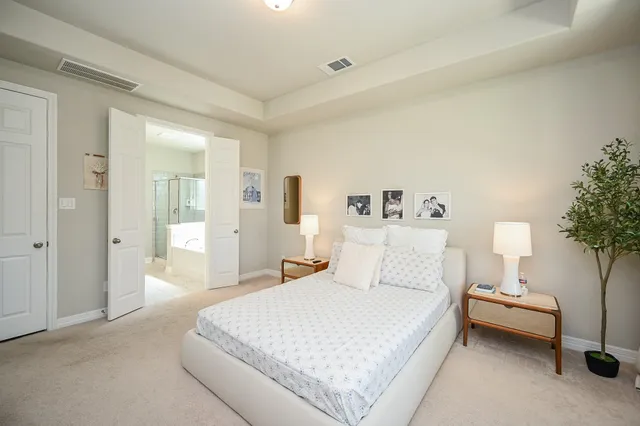 a bedroom with a bed and a lamp on dresser