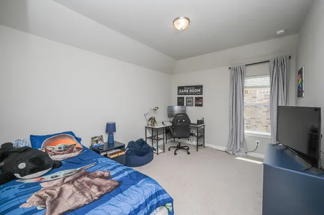 a bedroom with furniture and a flat screen tv