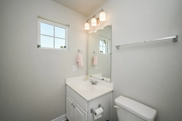 a bathroom with a sink a toilet and a mirror