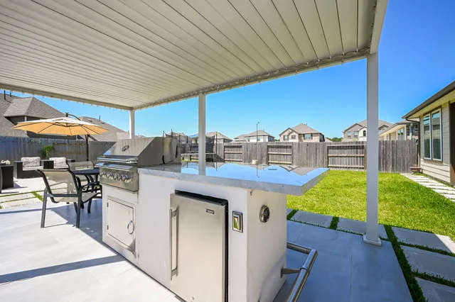 a view of a patio with table and chairs under an umbrella