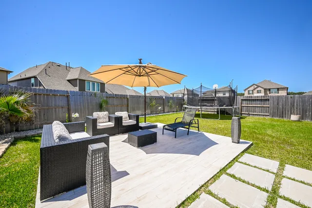 a view of a house with backyard sitting area and swimming pool