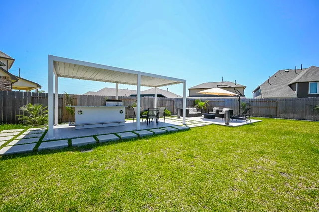a view of a swimming pool with table and chairs under an umbrella