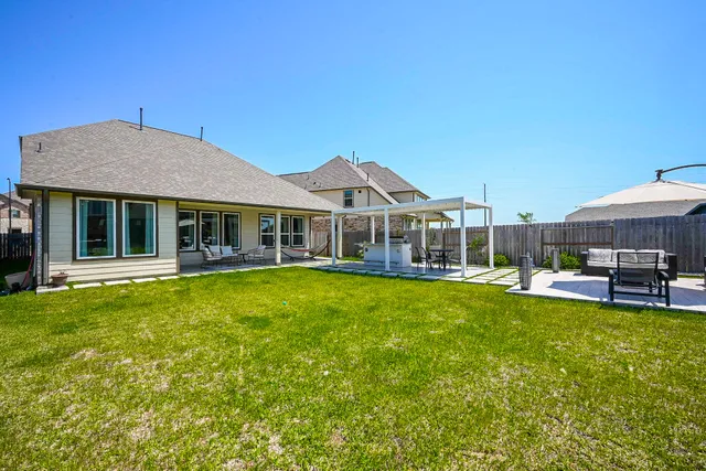 a front view of a house with a garden and swimming pool