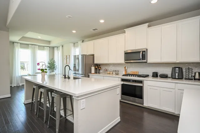 a kitchen with stainless steel appliances granite countertop a sink stove and microwave