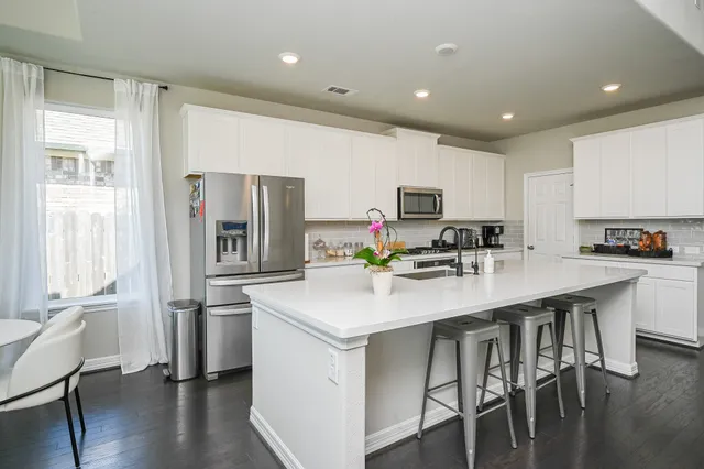 a kitchen with white cabinets and stainless steel appliances