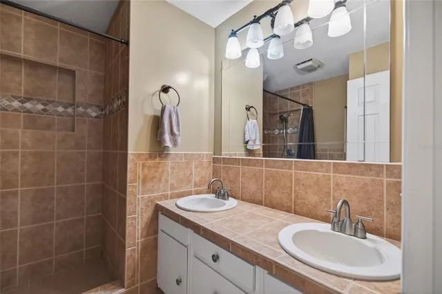 a bathroom with a sink vanity granite and a mirror