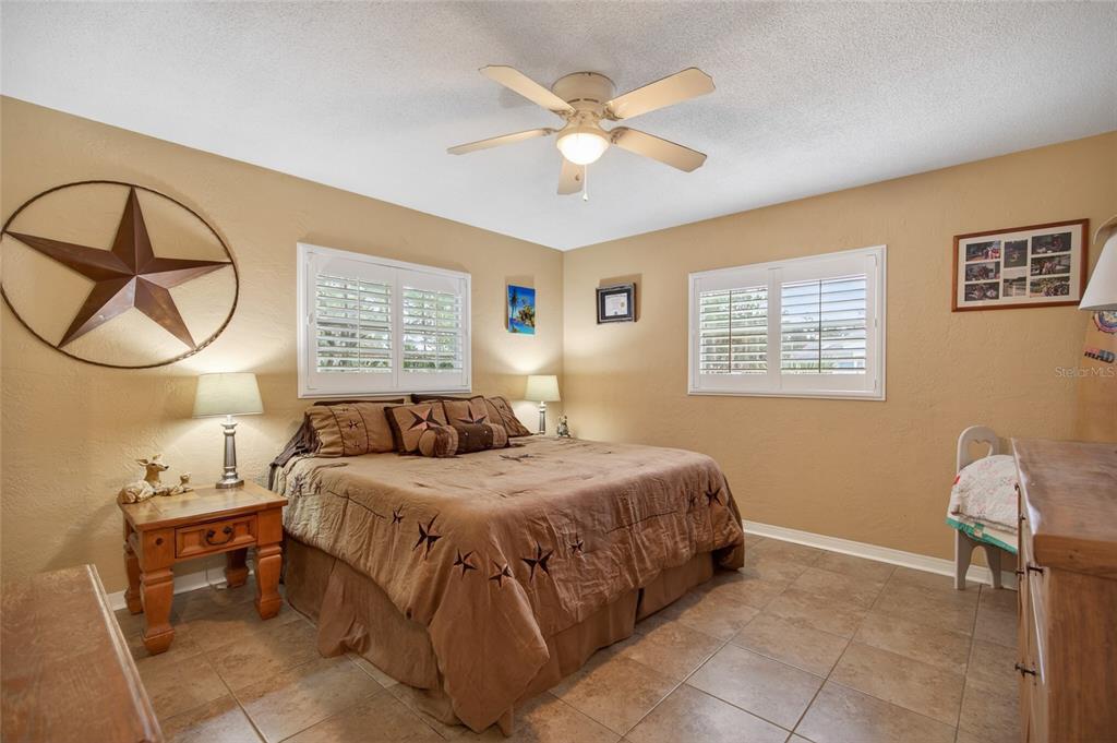 2218 River Ridge Road DeLand, FL 32720 - Photo 25 of 52 a bedroom with a bed a chandelier and a window