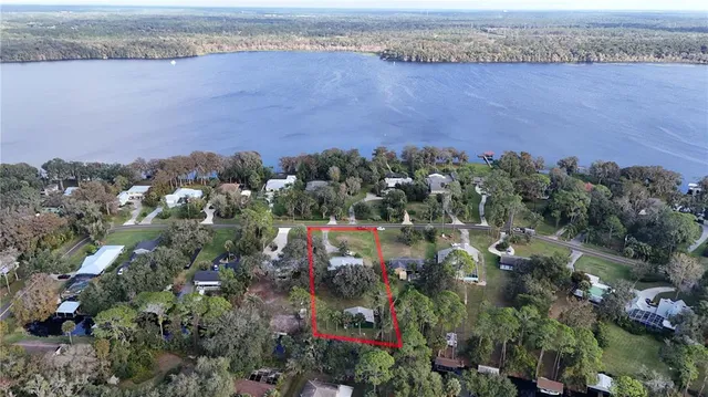 an aerial view of a house with a yard and lake view