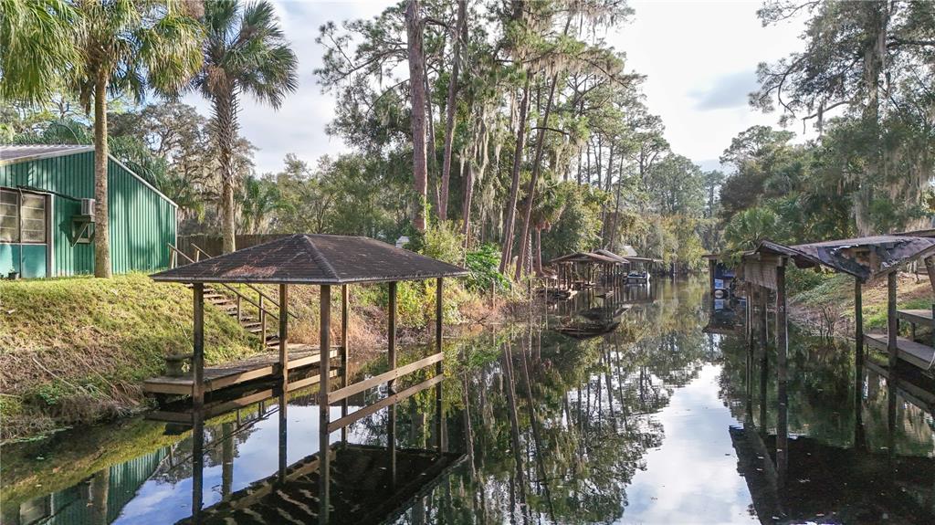 2218 River Ridge Road DeLand, FL 32720 - Photo 47 of 52 a view of a patio with lawn chairs under an umbrella