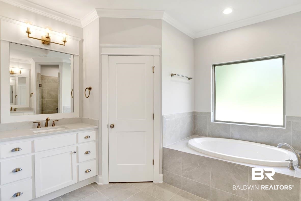 393 Garrison Boulevard Fairhope, AL 36532 - Photo 30 of 40 Bathroom featuring crown molding, vanity, tile patterned floors, and shower with separate bathtub