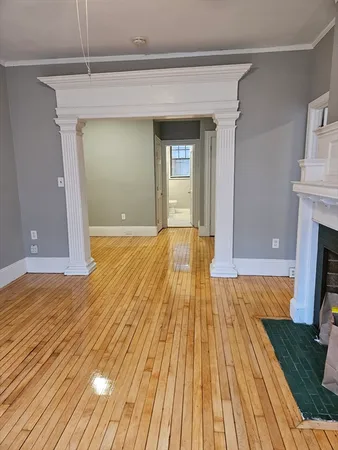 a view of empty room with wooden floor and fireplace