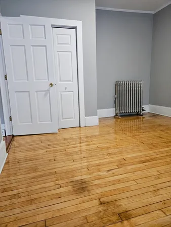 a view of a room with wooden floor and cabinet
