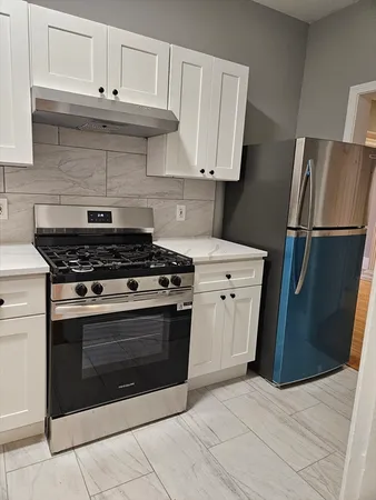 a kitchen with white cabinets and appliances