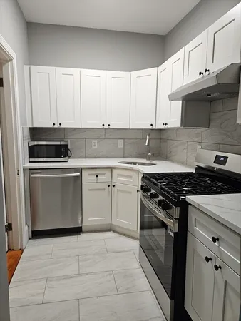 a kitchen with white cabinets and stainless steel appliances