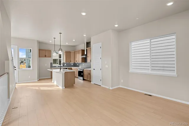 a kitchen with kitchen island granite countertop a stove a sink a center island and cabinets