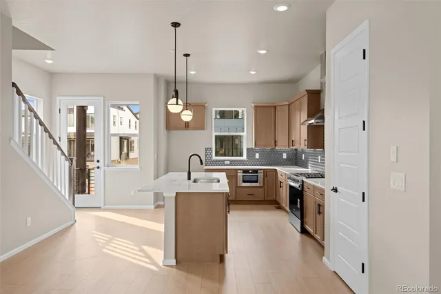 a kitchen with stainless steel appliances granite countertop a sink a stove top oven a counter space and cabinets