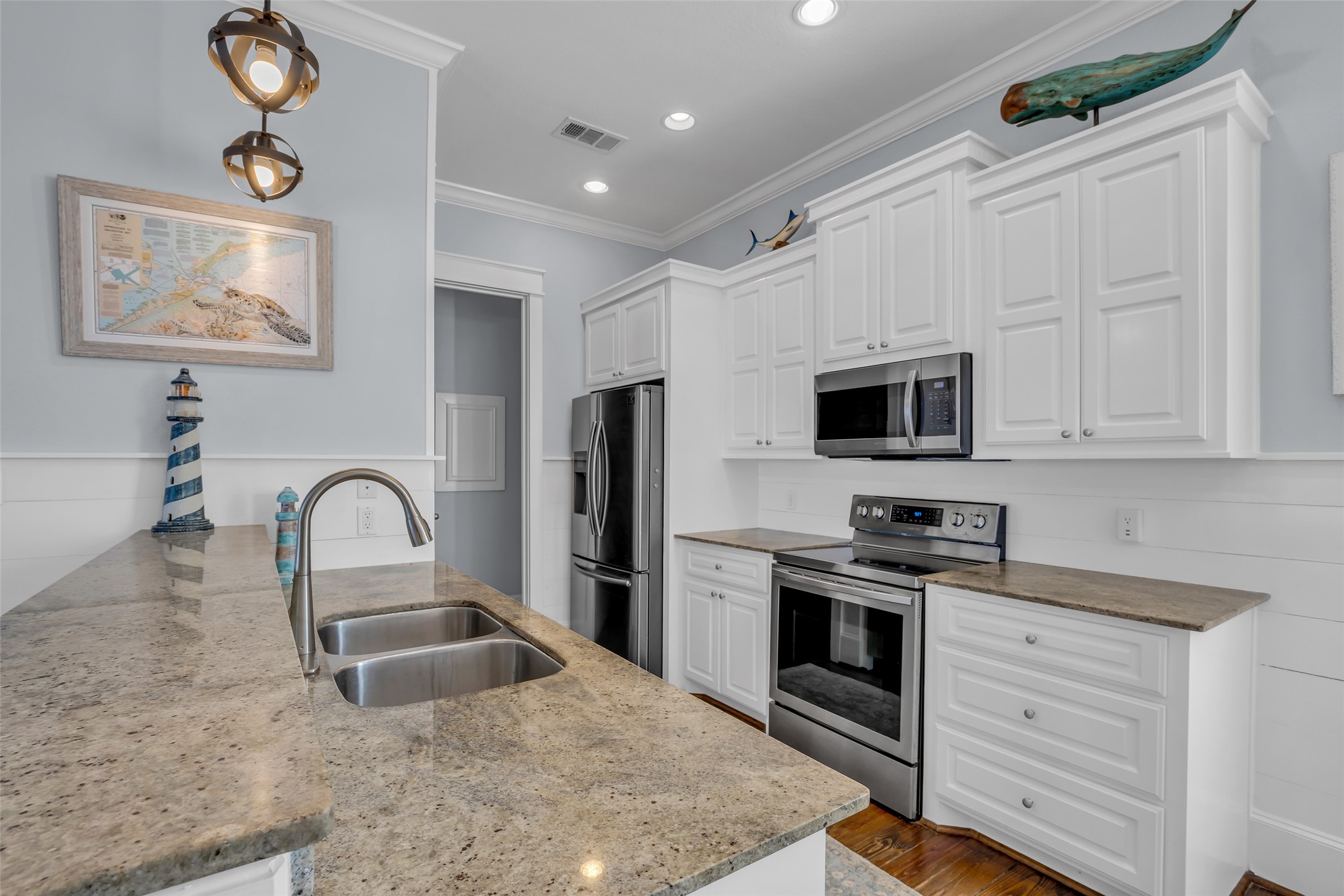 911 Tidelands Crystal Beach, TX 77650 - Photo 14 of 25 a kitchen with stainless steel appliances granite countertop a stove a sink and a microwave