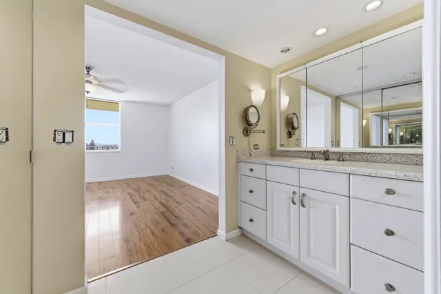 a spacious bathroom with a granite countertop sink mirror and a shower