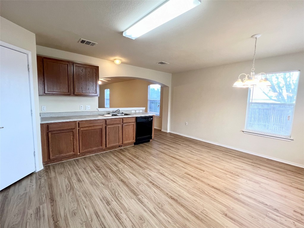 14200 Briarcreek Loop Manor, TX 78653 - Photo 12 of 20 a large kitchen with stainless steel appliances granite countertop a sink dishwasher a stove and a refrigerator with wooden floor