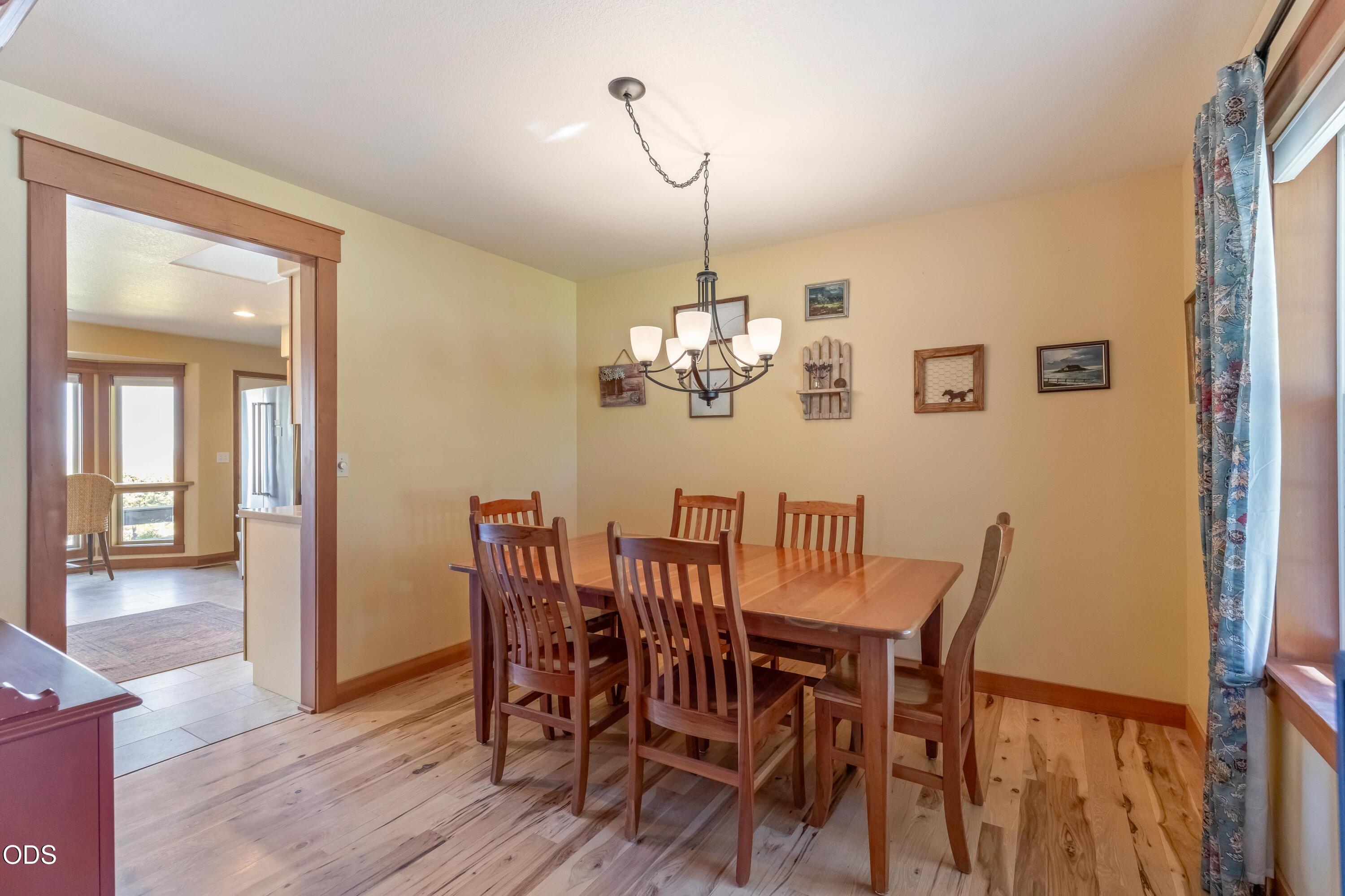 13753 South Sego Lily Road Powell Butte, OR 97753 - Photo 10 of 46 a view of a dining room with furniture wooden floor and chandelier