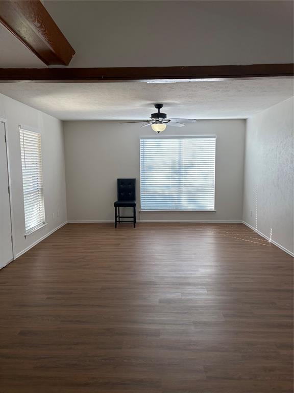 3717 Swallow Lane Irving, TX 75062 - Photo 4 of 11 Unfurnished living room featuring dark wood finished floors, a ceiling fan, and a textured ceiling