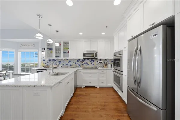 a kitchen with granite countertop a sink cabinets and wooden floor