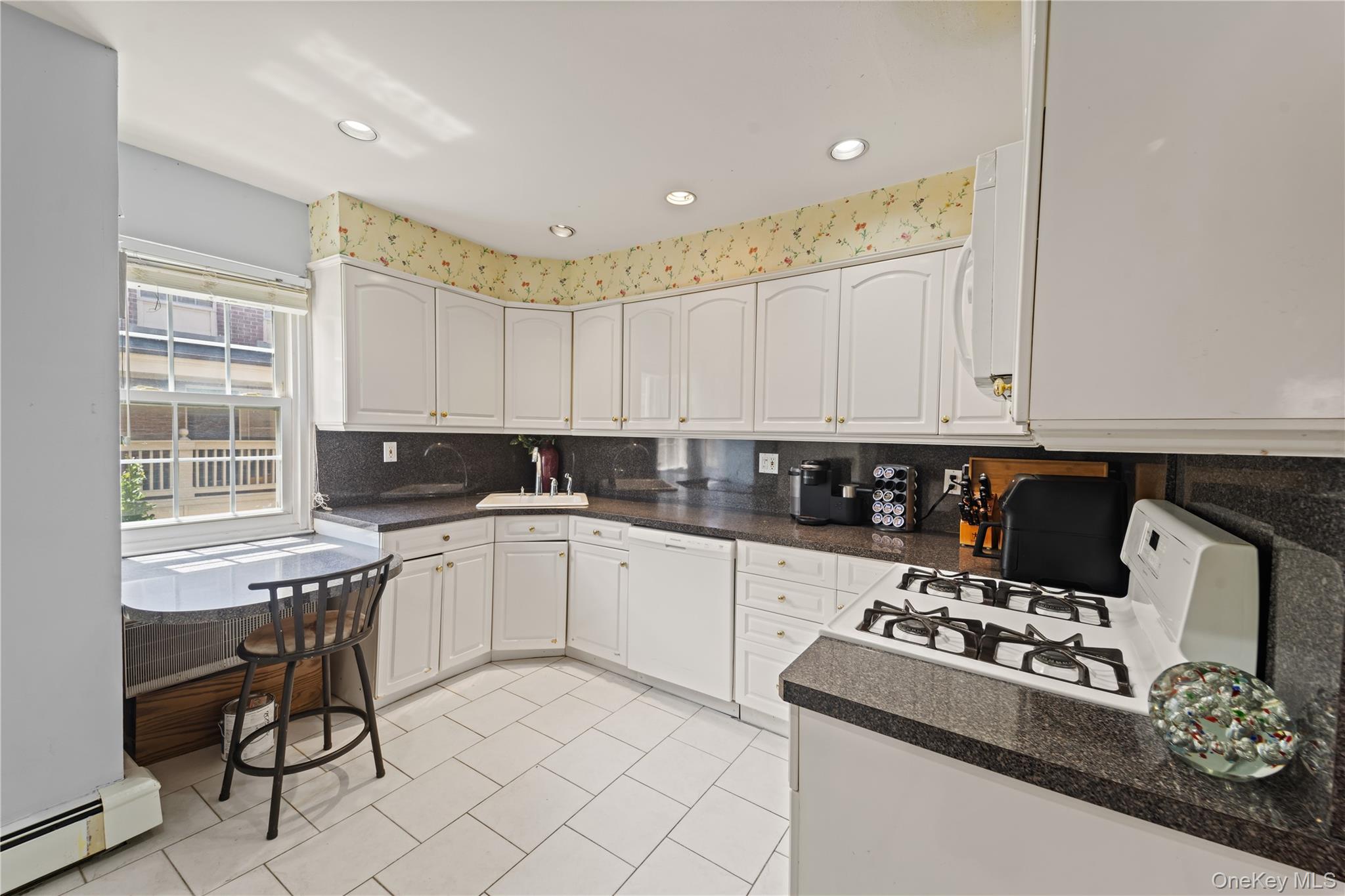 12-35 Robin Lane, Unit UPPR Queens, NY 11360 - Photo 16 of 23 Kitchen with tasteful backsplash, white cabinetry, a baseboard heating unit, white appliances, and light tile patterned flooring