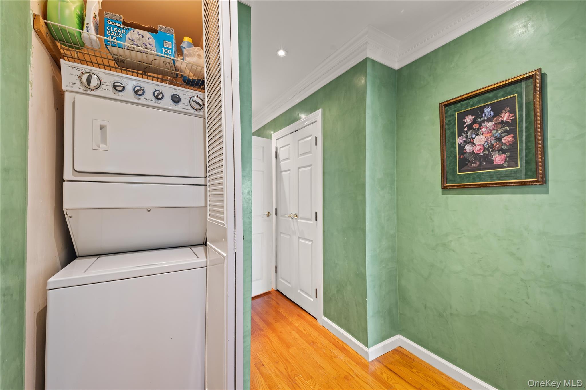 12-35 Robin Lane, Unit UPPR Queens, NY 11360 - Photo 17 of 23 Laundry area featuring ornamental molding, wood finished floors, stacked washing machine and dryer, and recessed lighting